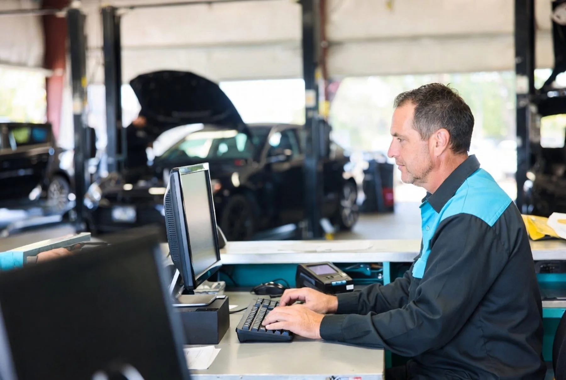 Service writer at a counter in a busy auto repair shop