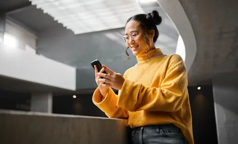 Person using their phone in a modern lobby